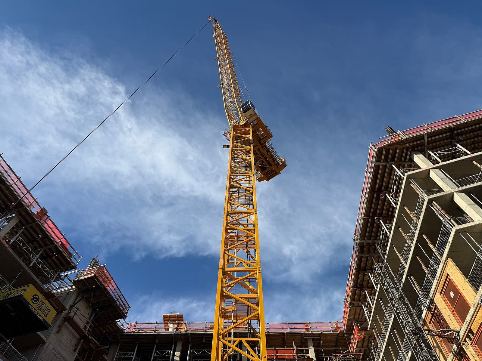 Tower crane menjulang di antara dua bangunan proyek